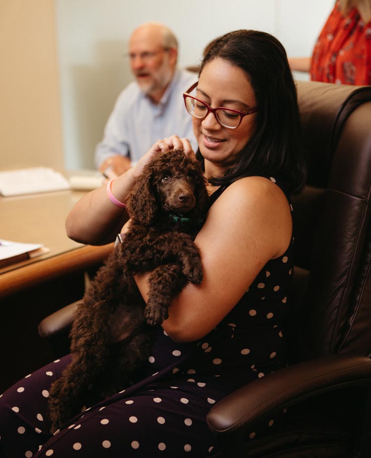 Paralegal Maria Moran holding a little dog